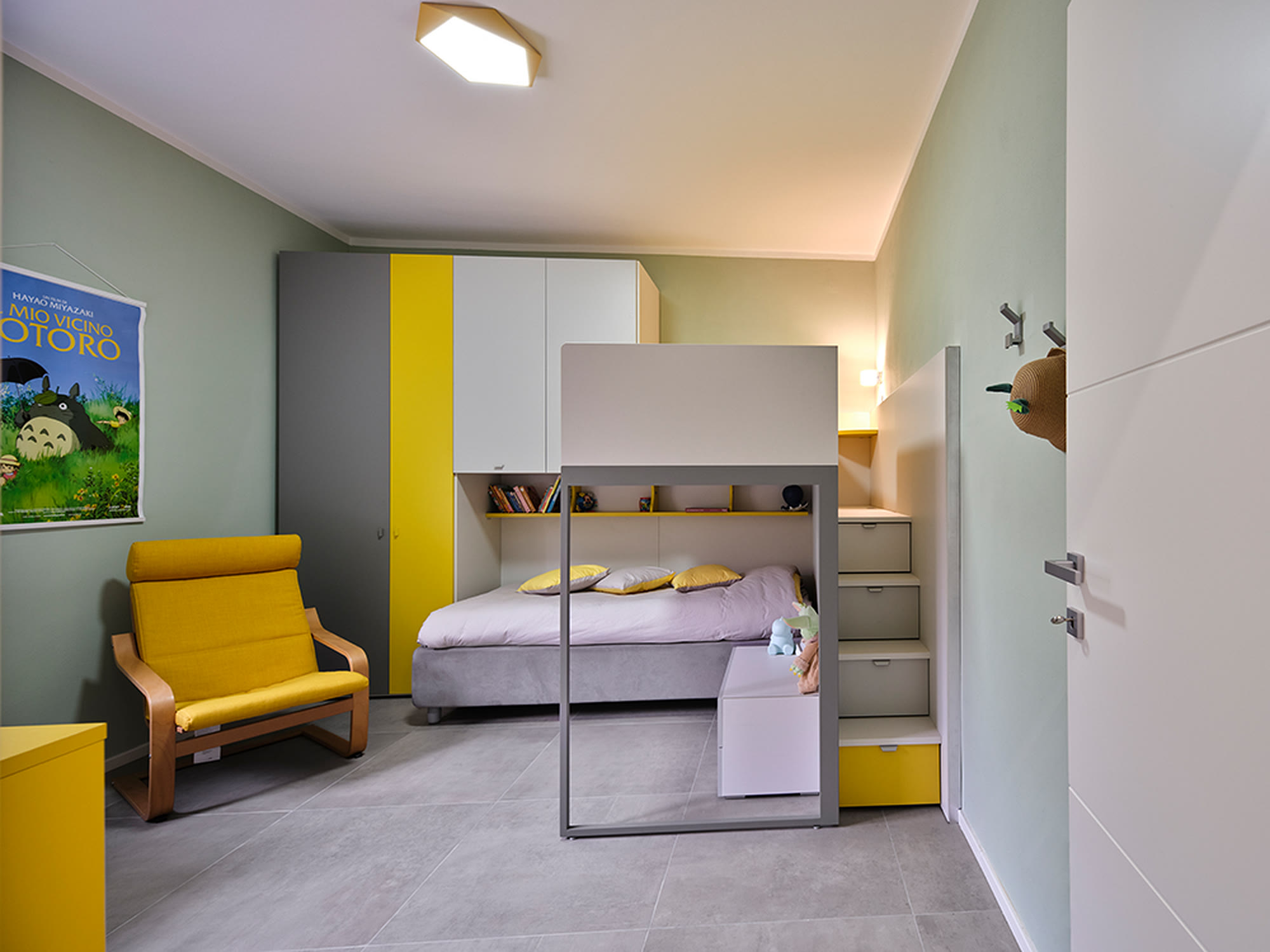 Cameretta con letto a soppalco, armadio angolare bianco e dettagli gialli.
