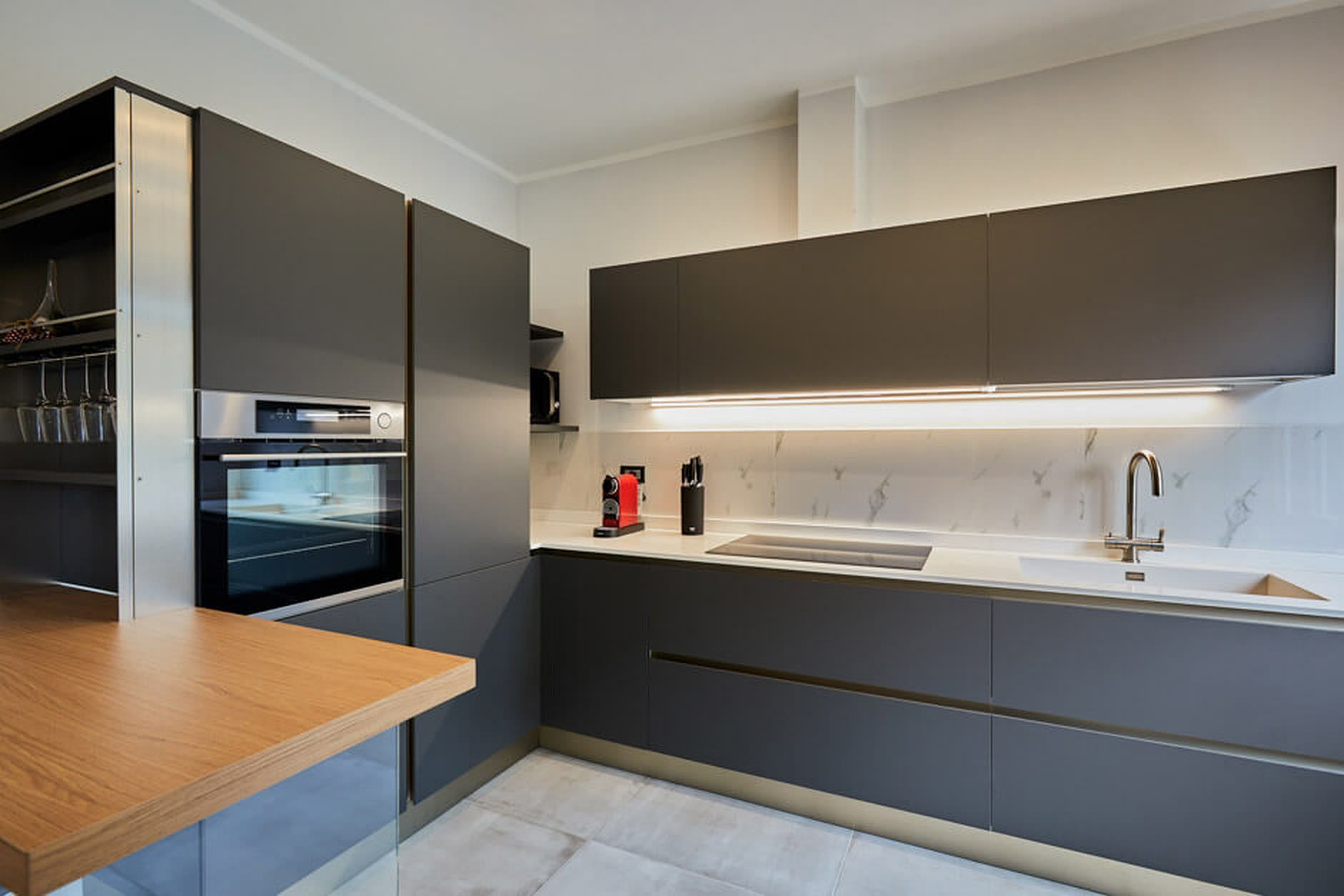 Cucina antracite e bianco con piano a induzione e colonne dispensa.